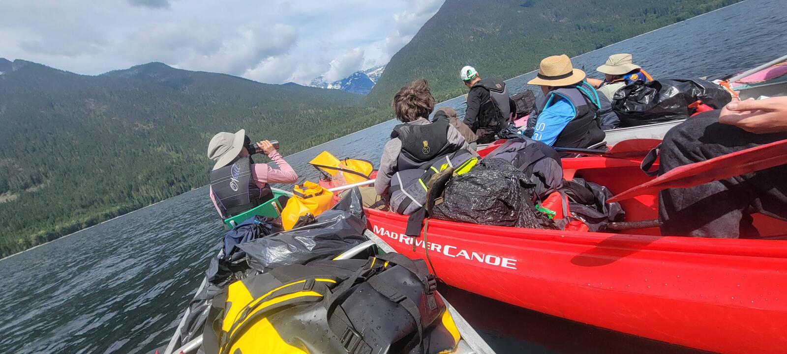 Scouts paddling canoes on a turquoise lake in the North Cascades