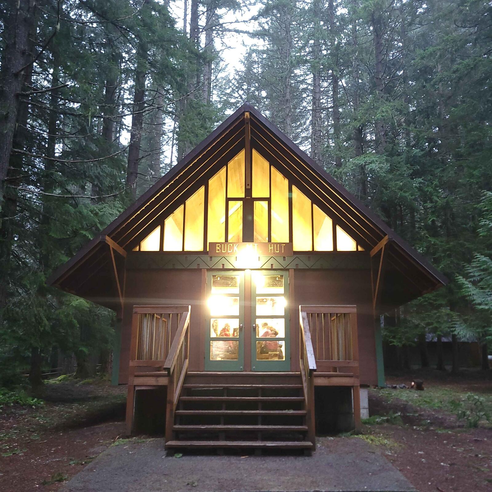 Buck Hut lodge lit up at dusk at Camp Sheppard